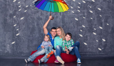 Family sitting under a colorful umbrella, symbolizing FERS survivor benefit protection.