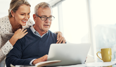 Couple reviewing federal retirement planning on a laptop, looking confident and optimistic.