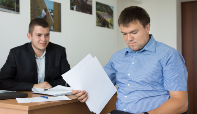 Two men reviewing paperwork in an office, discussing disability benefits for federal employees.