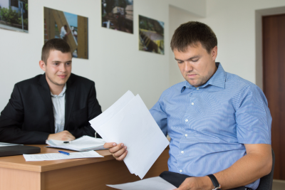 Two men reviewing paperwork in an office, discussing disability benefits for federal employees.